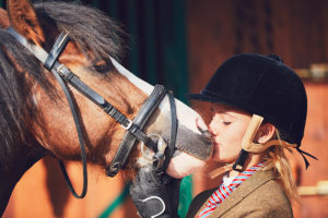 Mädchen mit Reithelm und Pony