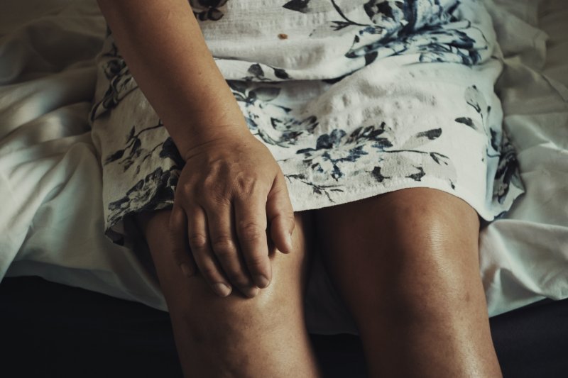 Frau hält Knie fest
