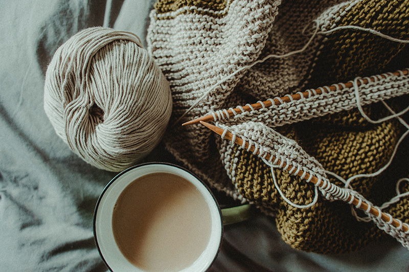 Stricknadeln mit Strickstück und Wolle