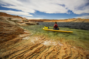 Mann mit Schwimmweste auf SUP-Board