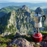 Gaskartusche mit Kocheraufsatz und Kaffeekanne auf einem Berggipfel