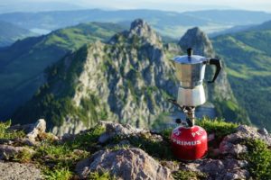 Gaskartusche mit Kocheraufsatz und Kaffeekanne auf einem Berggipfel
