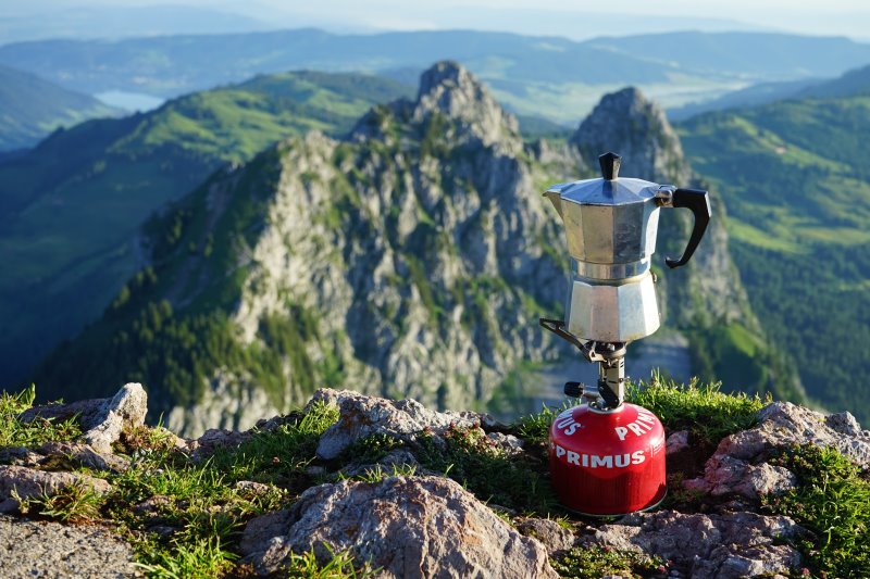 Gaskartusche mit Kocheraufsatz und Kaffeekanne auf einem Berggipfel