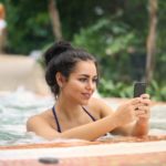 Outdoor Whirlpool, Frau anSmartphone