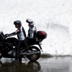 Motorradfahrer und Sozius unterhalten sich im Stand auf dem Motorrad
