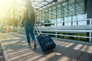 Reisende zieht ihre Reisetasche mit Rollen