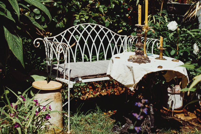 Weiße Sitzbank aus Metall im Garten