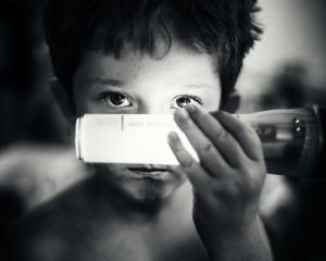 Ein Kind hält sich eine Kinder-Taschenlampe vor sein Gesicht
