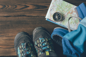 Foto von Wanderschuhe, Wanderrucksack, Kompass und Wanderkarte im Flatlay