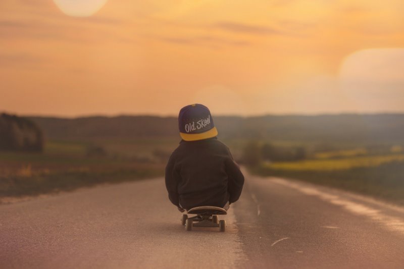 auf einem Rollbrett sitzender Junge