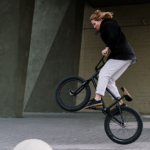 Eine Frau die ein BMX-Trick demonstriert.