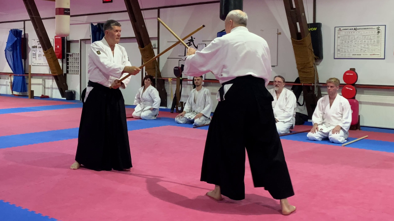 Aikido-Training mit Holzwaffen in einer traditionellen Halle